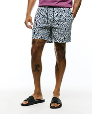Mens Eddy All Over Print Swim Trunk in navy and white, featuring a classic fit, smooth fabric, and an all-over geometric cube pattern with small Psycho Bunny skull logos. Includes a drawstring waist, branded tag, and small embroidered logo.