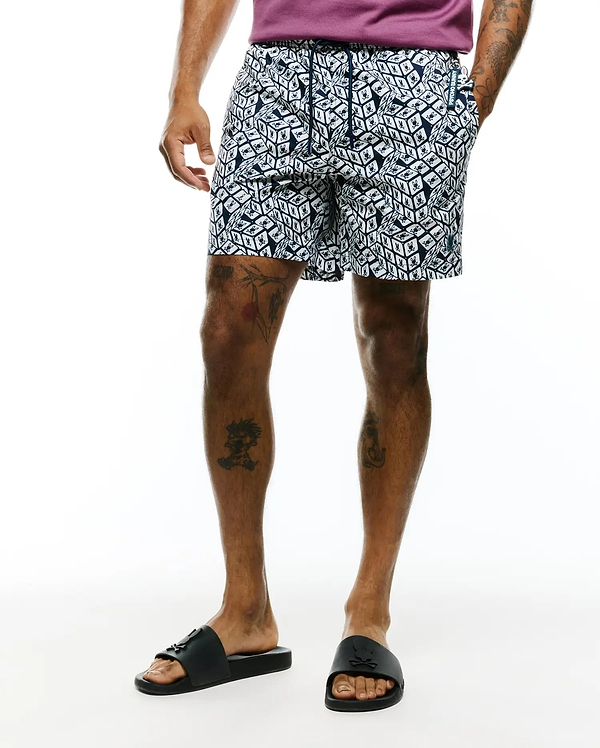 Mens Eddy All Over Print Swim Trunk in navy and white, featuring a classic fit, smooth fabric, and an all-over geometric cube pattern with small Psycho Bunny skull logos. Includes a drawstring waist, branded tag, and small embroidered logo.