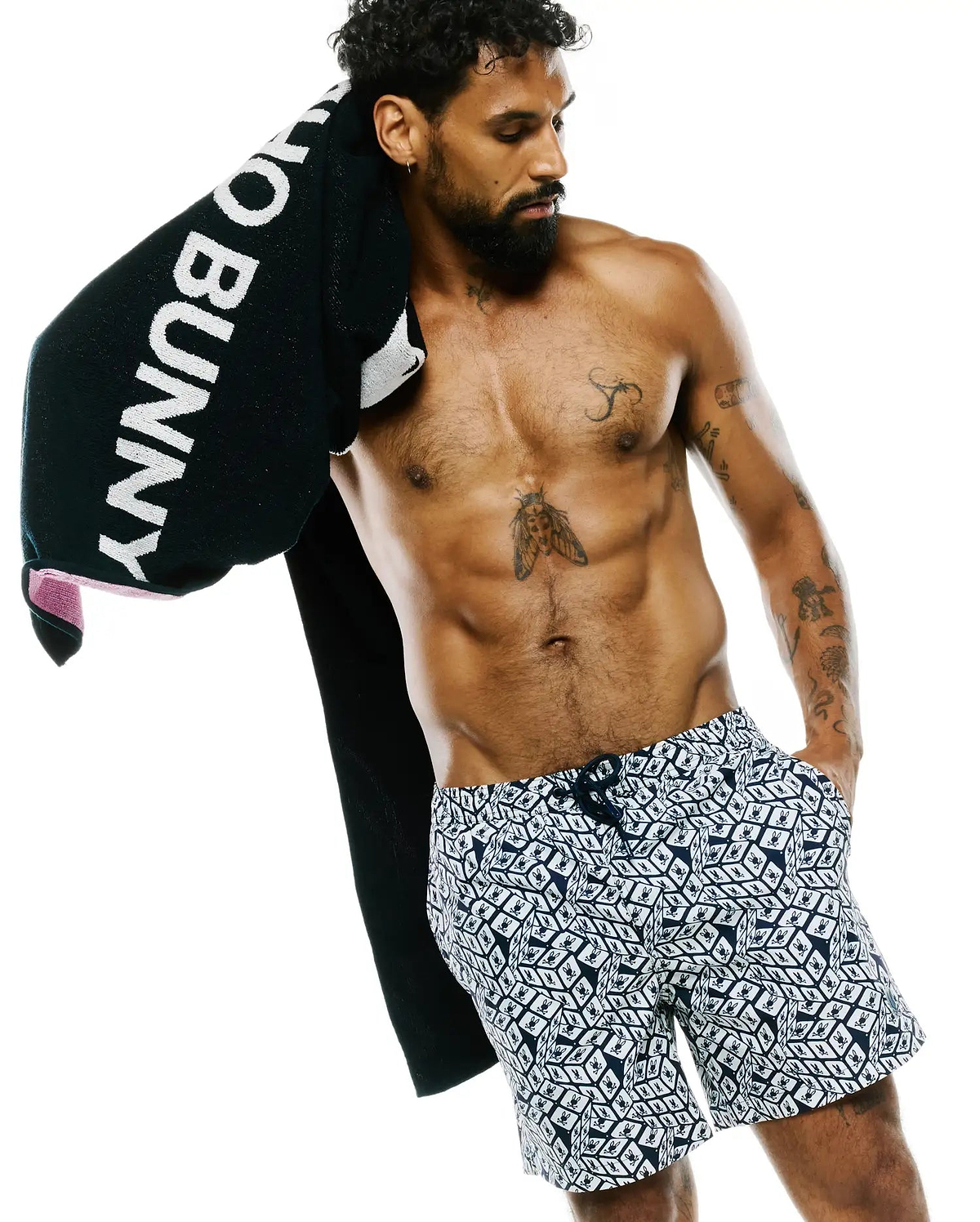 Mens Eddy All Over Print Swim Trunk, a classic fit, navy and white design with an all-over geometric pattern featuring repeated small Psycho Bunny skull logos.