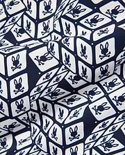 Mens Eddy All Over Print Swim Trunk, navy and white, featuring a repeating geometric cube pattern with the iconic Psycho Bunny skull logo on smooth fabric.
