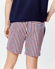 Mens John All Over Print Swim Trunk, a classic fit with vibrant vertical stripes in white, red, and navy blue, featuring a small striped back pocket on smooth fabric.