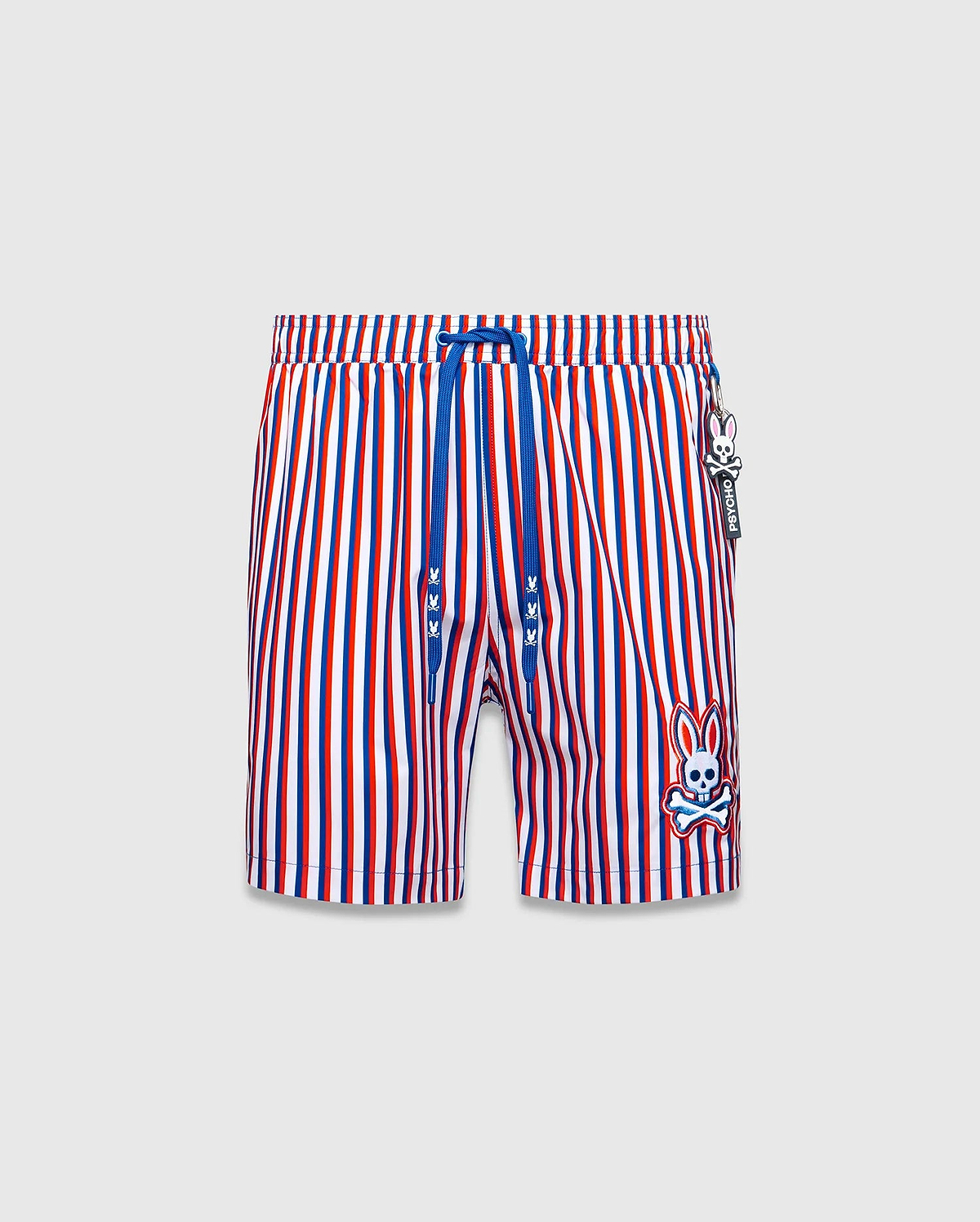 Mens John All Over Print Swim Trunk, red, white, blue vertical stripes, blue drawstring with mini bunny skulls, large embroidered Psycho Bunny skull logo on left leg, and Psycho Bunny tag.