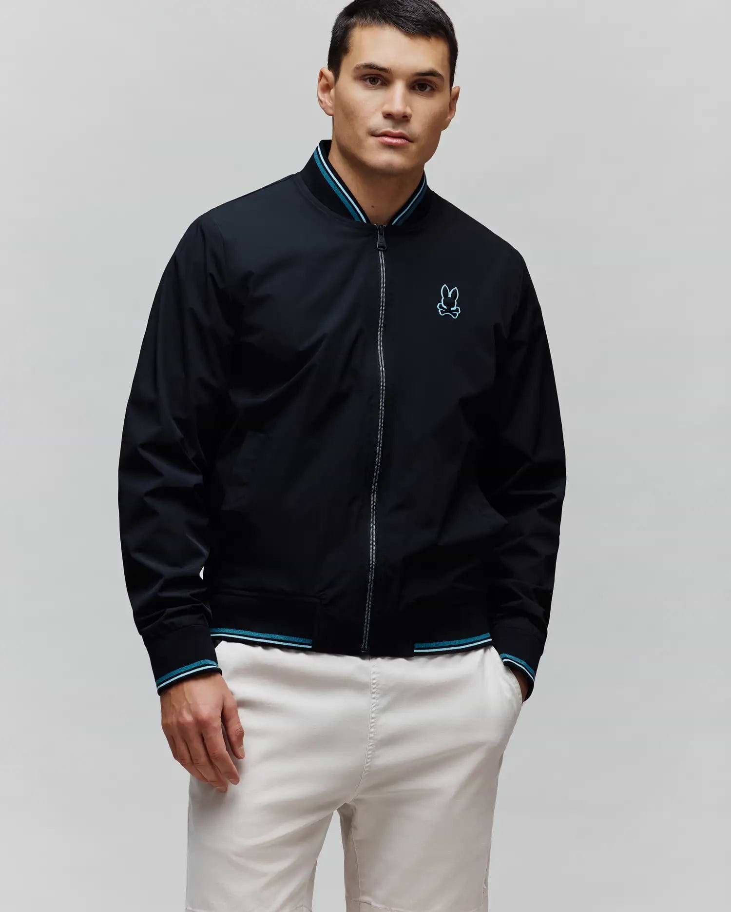 Black Mens Aldrin Bomber jacket, classic fit, featuring a full zip, teal and white striped ribbed collar and cuffs, and an embroidered light blue Psycho Bunny skull logo on the left chest.