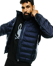 Mens Emerik Hooded Puffer Jacket in dark navy, with horizontal quilting and full zip. Layered over a black jersey t-shirt featuring a large grey Psycho Bunny skull logo with subtle pattern on the chest.