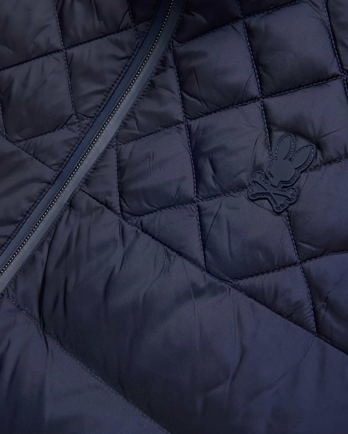 Mens Emerik Puffer Jacket, a navy quilted puffer jacket crafted from smooth nylon, featuring a dark zipper and a small, rubberized Psycho Bunny skull logo on the chest.