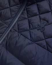 Mens Emerik Puffer Jacket, a navy quilted puffer jacket crafted from smooth nylon, featuring a dark zipper and a small, rubberized Psycho Bunny skull logo on the chest.