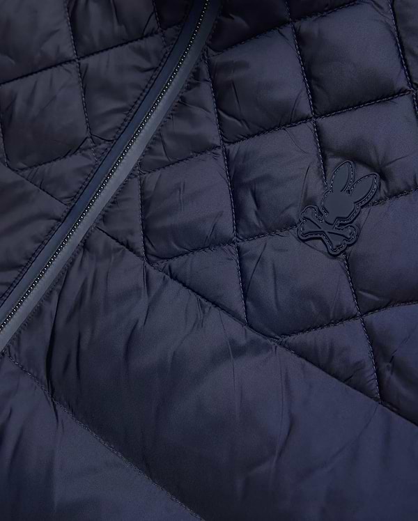 Mens Emerik Puffer Jacket, a navy quilted puffer jacket crafted from smooth nylon, featuring a dark zipper and a small, rubberized Psycho Bunny skull logo on the chest.
