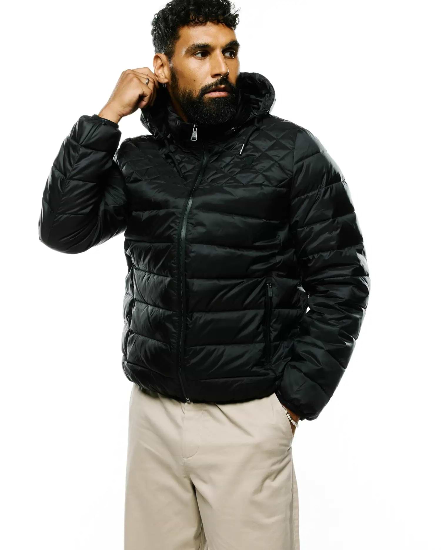 Mens Emerik Hooded Puffer Jacket in black, featuring a classic fit, shiny quilted fabric with diamond pattern on shoulders, horizontal quilting on body, full zip, and a small Psycho Bunny skull logo on the left chest.