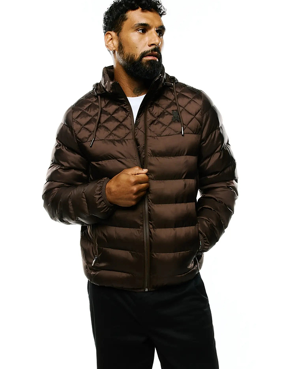 Mens Emerik Hooded Puffer Jacket in rich brown, featuring a quilted upper, horizontal puffer channels, a full zip, and a small black embroidered Psycho Bunny skull logo on the left chest.