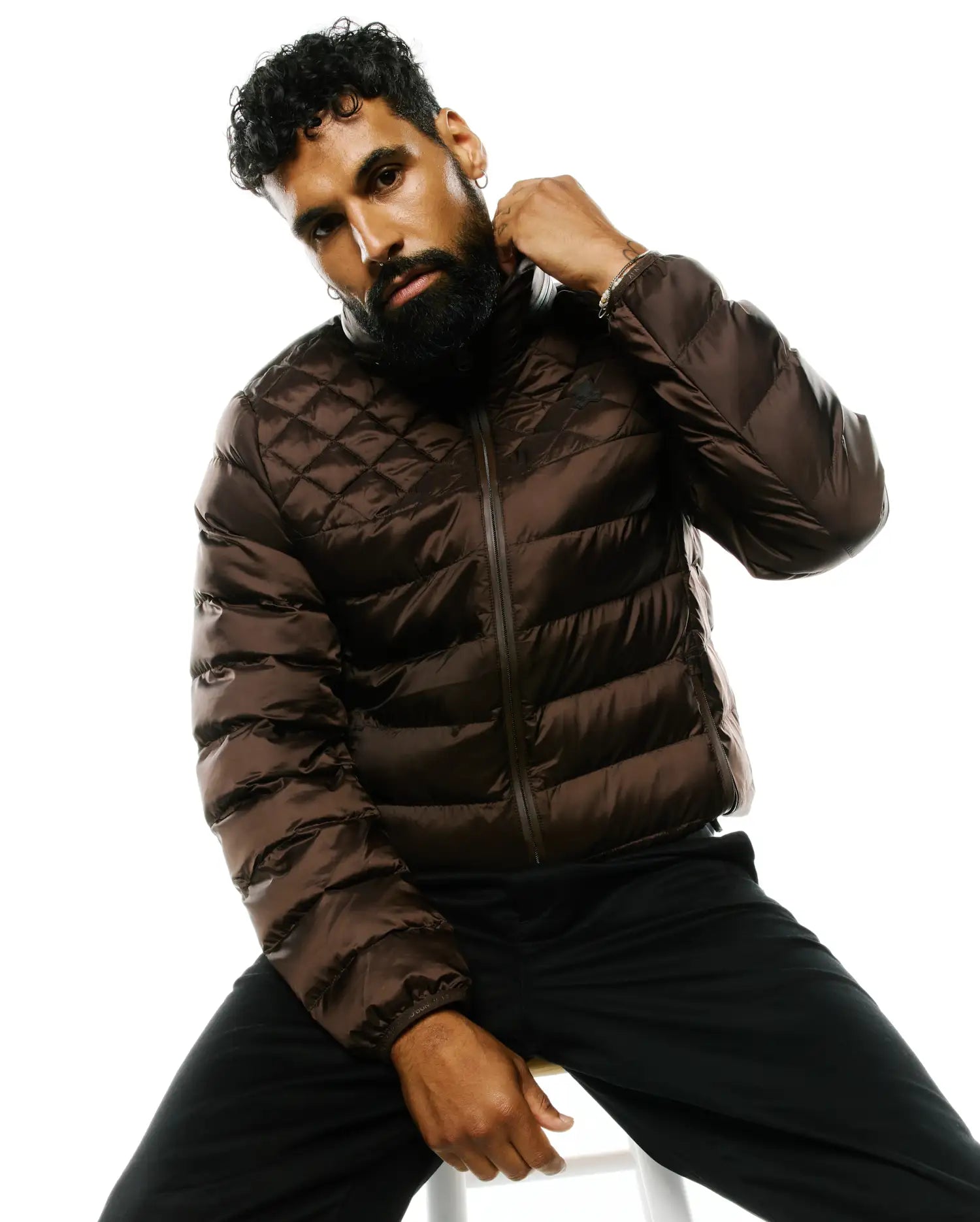 Mens Emerik Hooded Puffer Jacket in shiny rich brown, featuring a quilted upper, horizontal baffles, full zip, and small embroidered Psycho Bunny skull logo on left chest.