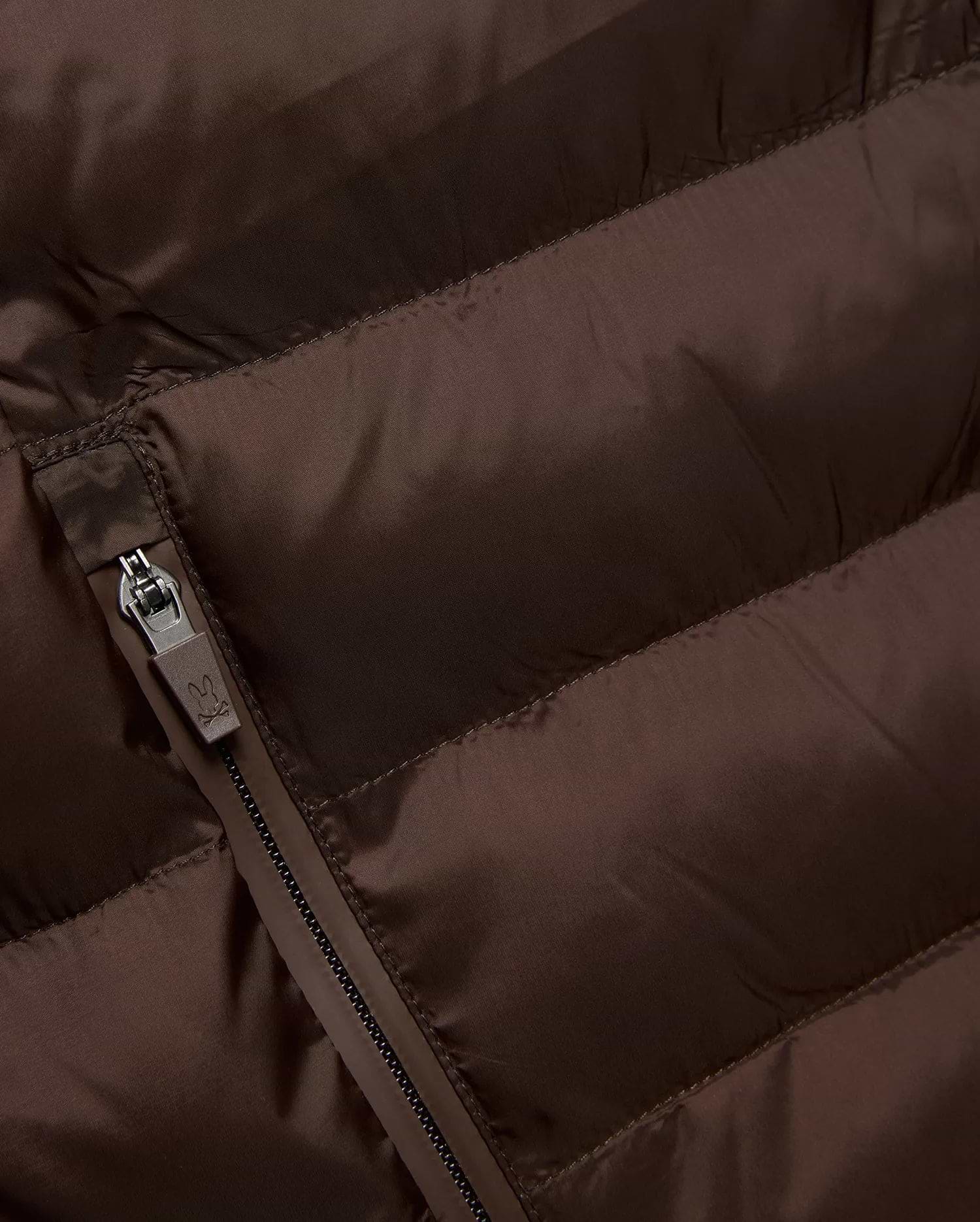 Mens Emerik Puffer Jacket in rich brown, crafted from smooth, quilted nylon. Features horizontal puffer channels and a dark grey zipper with a small Psycho Bunny skull logo pull.