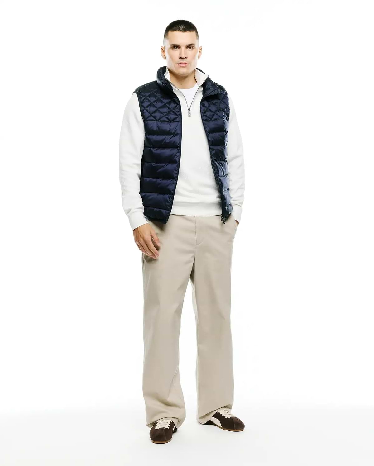 Mens Emerik Quilted Puffer Vest in navy, featuring a diamond quilted pattern, full zip front, stand collar with white lining, and a small Psycho Bunny skull logo on the zipper pull. Classic fit.