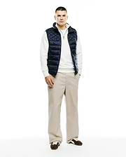 Mens Emerik Quilted Puffer Vest in navy, featuring a diamond quilted pattern, full zip front, stand collar with white lining, and a small Psycho Bunny skull logo on the zipper pull. Classic fit.
