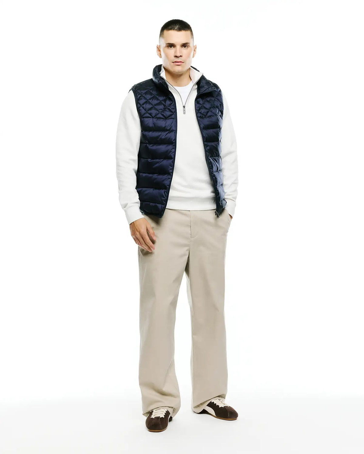 Mens Emerik Quilted Puffer Vest in navy, featuring a diamond quilted pattern, full zip front, stand collar with white lining, and a small Psycho Bunny skull logo on the zipper pull. Classic fit.