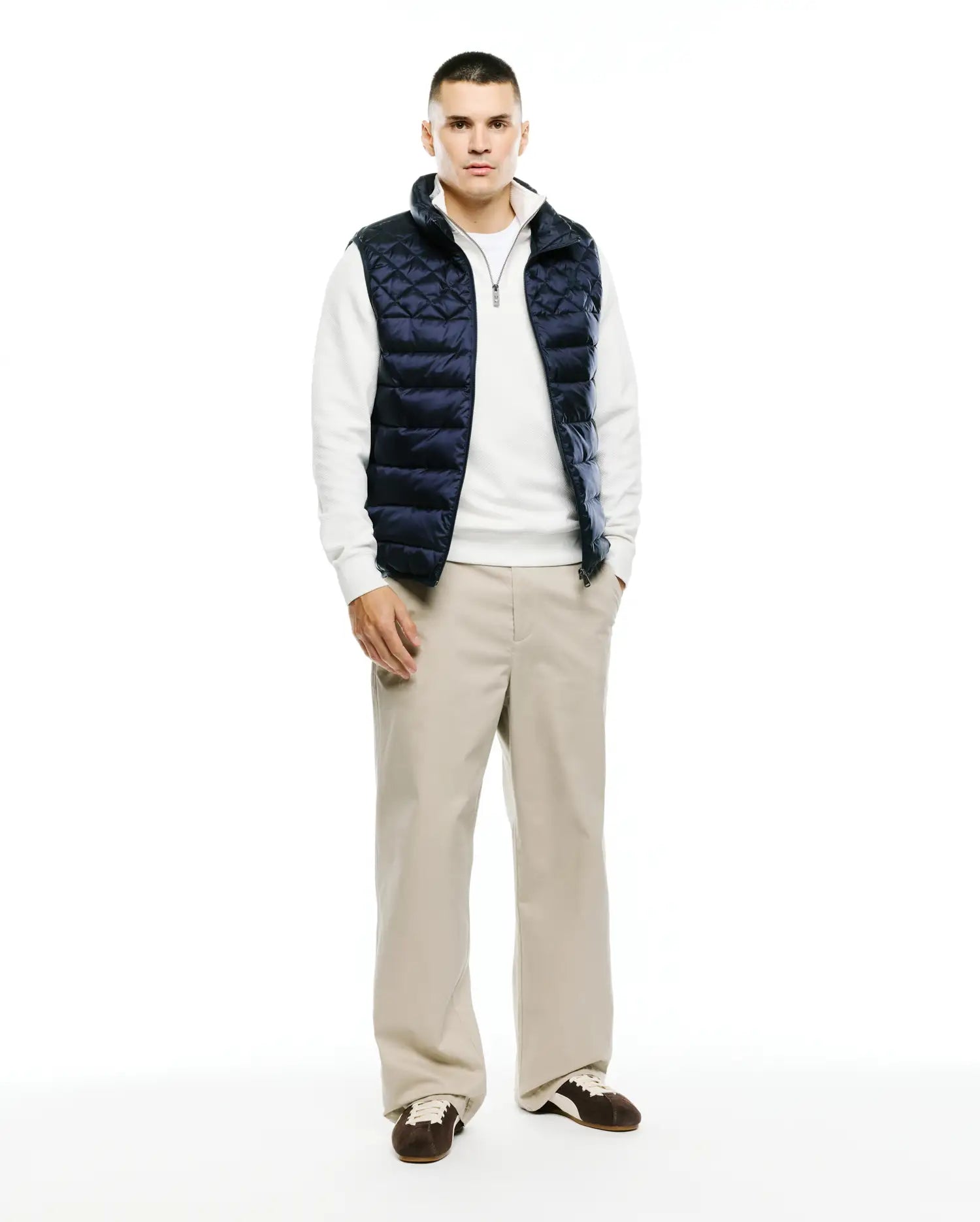 Mens Emerik Quilted Puffer Vest in navy, featuring a diamond quilted pattern, full zip front, stand collar with white lining, and a small Psycho Bunny skull logo on the zipper pull. Classic fit.