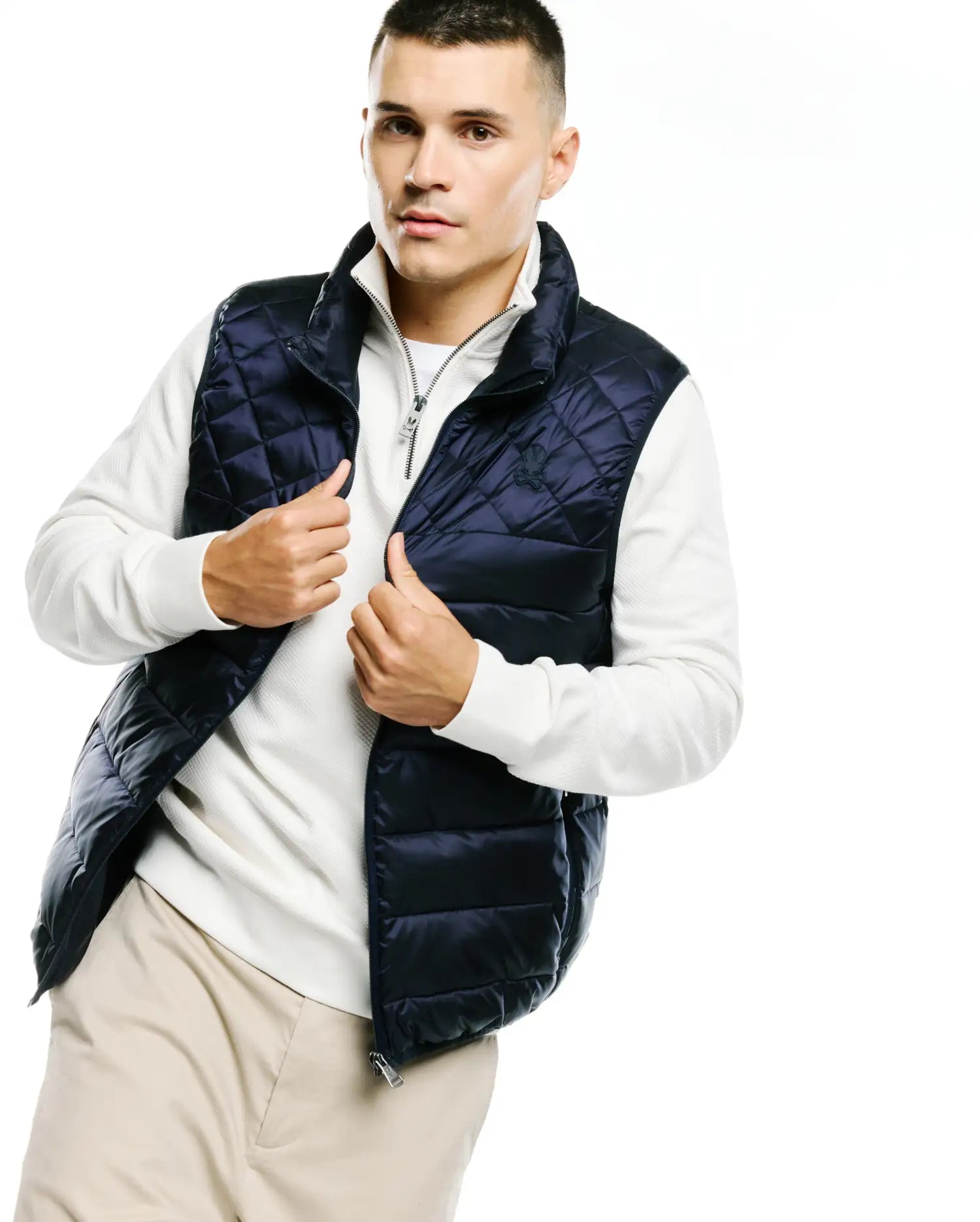 Mens Emerik Quilted Puffer Vest in navy blue, featuring diamond quilting, a full zip closure with a branded pull, and a small embroidered Psycho Bunny skull logo on the left chest.