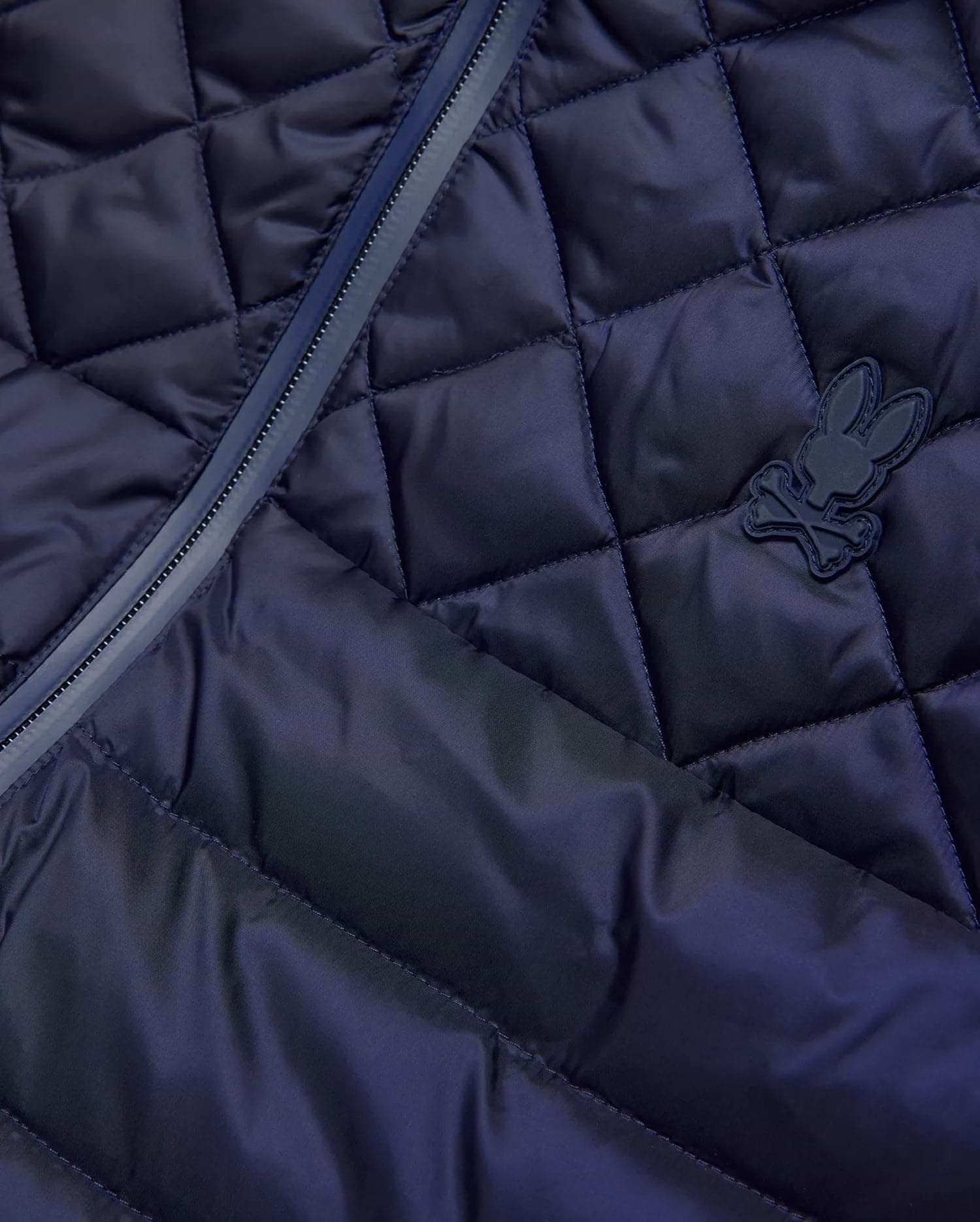 Mens Emerik Puffer Vest in navy, featuring a diamond quilted pattern, full-zip closure with dark trim, and a small, matching navy rubberized Psycho Bunny skull logo on the chest.