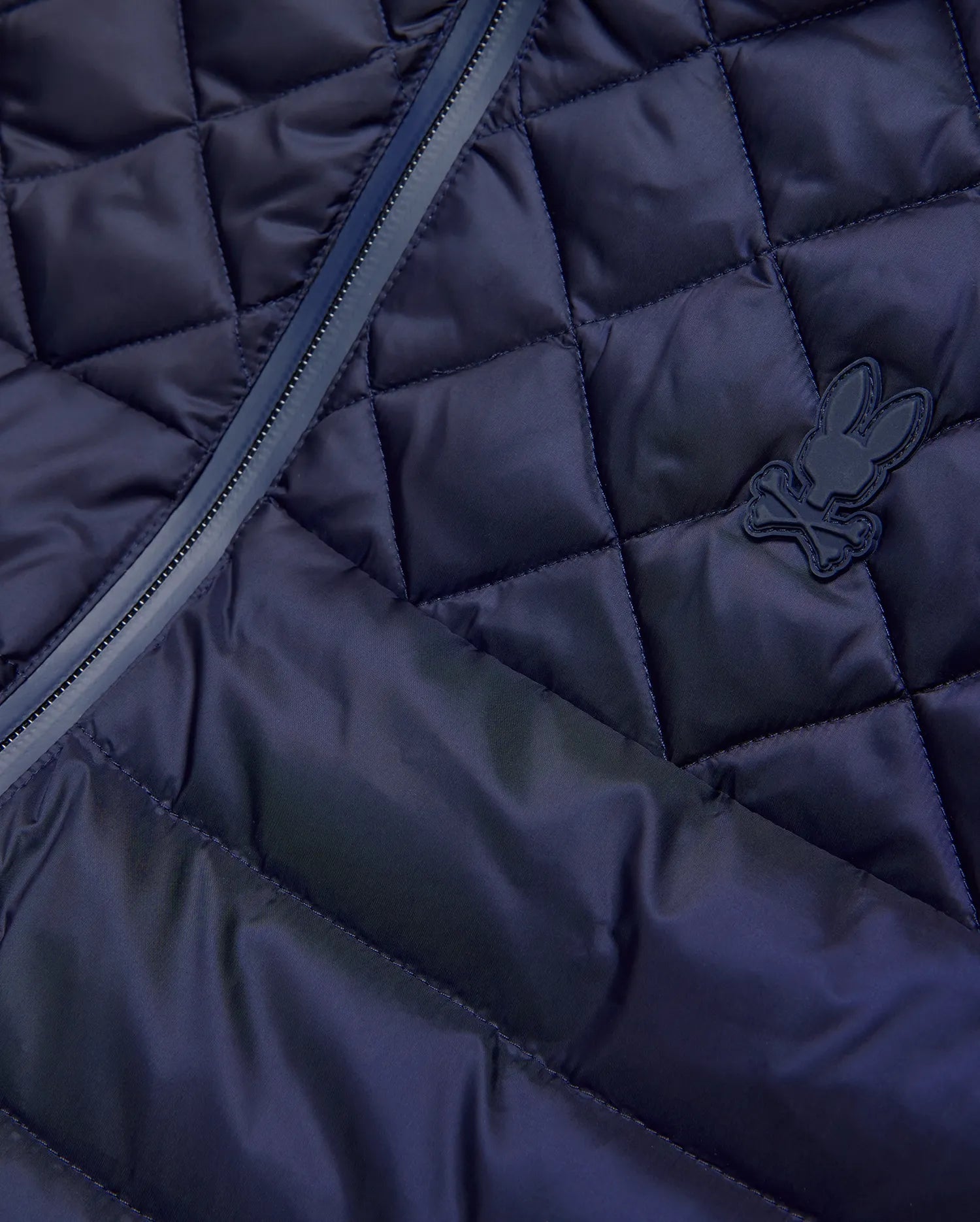 Mens Emerik Puffer Vest in navy, featuring a diamond quilted pattern, full-zip closure with dark trim, and a small, matching navy rubberized Psycho Bunny skull logo on the chest.
