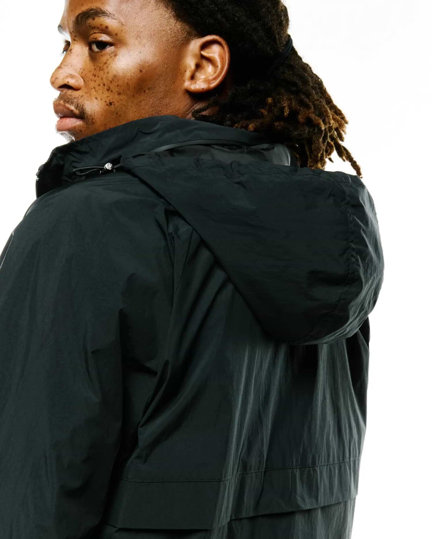 Psycho Bunny's Mens Javier Nylon Windbreaker Jacket in dark forest green, featuring a relaxed fit, crinkled nylon fabric, and an adjustable hood with a silver drawstring toggle. (2)