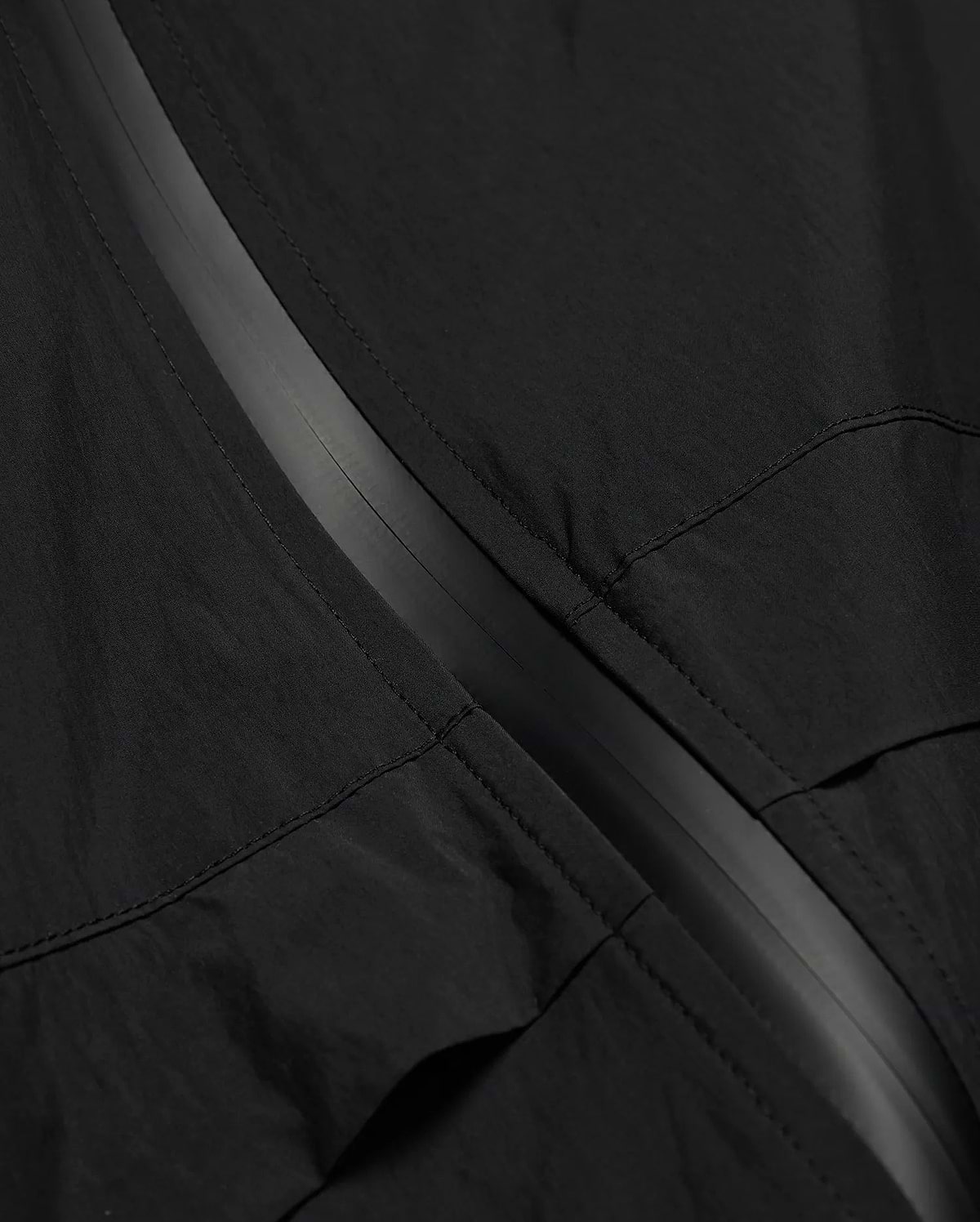 MENS JAVIER WINDBREAKER JACKET in black, featuring a subtle dark grey central zipper strip and visible panel stitching on lightweight, crinkled fabric. (6)