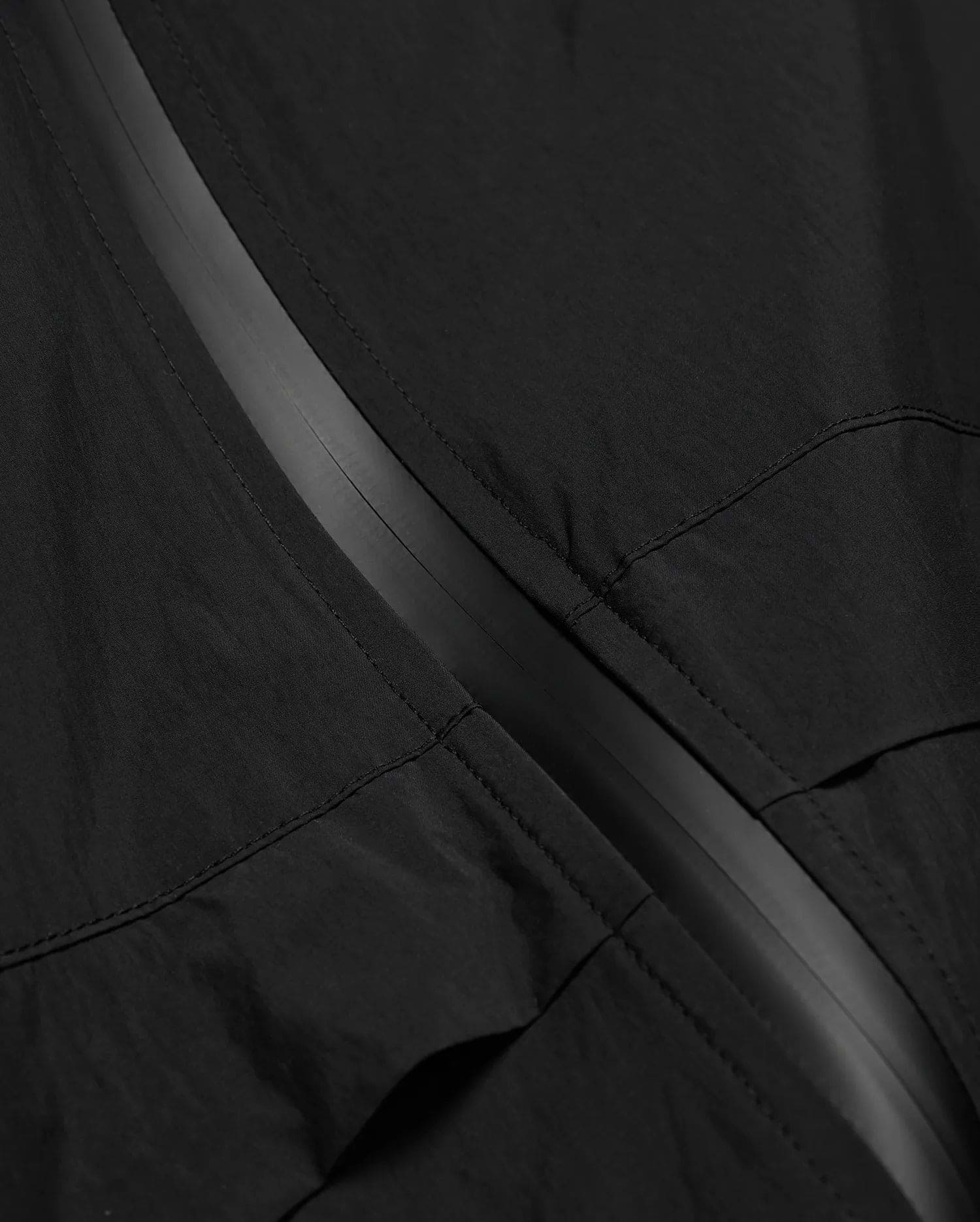 MENS JAVIER WINDBREAKER JACKET in black, featuring a subtle dark grey central zipper strip and visible panel stitching on lightweight, crinkled fabric. (6)