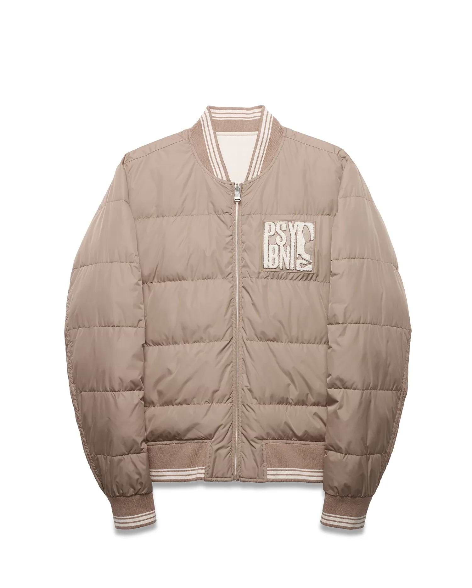 Men's Franco Reversible Bomber, a beige quilted jacket with white striped ribbed collar, cuffs, and hem, featuring a large embroidered Psycho Bunny text and skull logo patch on the left chest. (5)