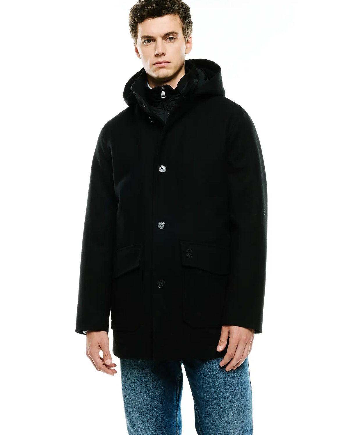 Mens Luther Wool Blend Coat, a classic fit black hooded coat with a smooth wool blend texture, featuring a button-front closure with distinctive silver buttons, two front flap pockets, and a small embroidered Psycho Bunny skull logo on the right pocket.