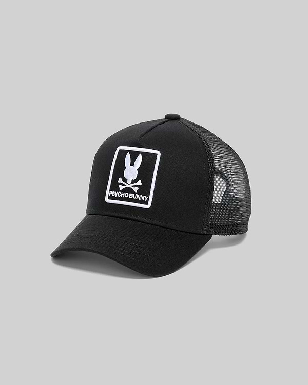 Mens Adamo Trucker Cap, black cotton twill front with a large white embroidered Psycho Bunny skull logo and text in a rectangular border, featuring a breathable black mesh back.