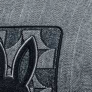 Grey herringbone jacket with black ribbed collar and large embroidered Psycho Bunny skull logo on back, paired with a black Jimmy Baseball Cap featuring a metal logo buckle.