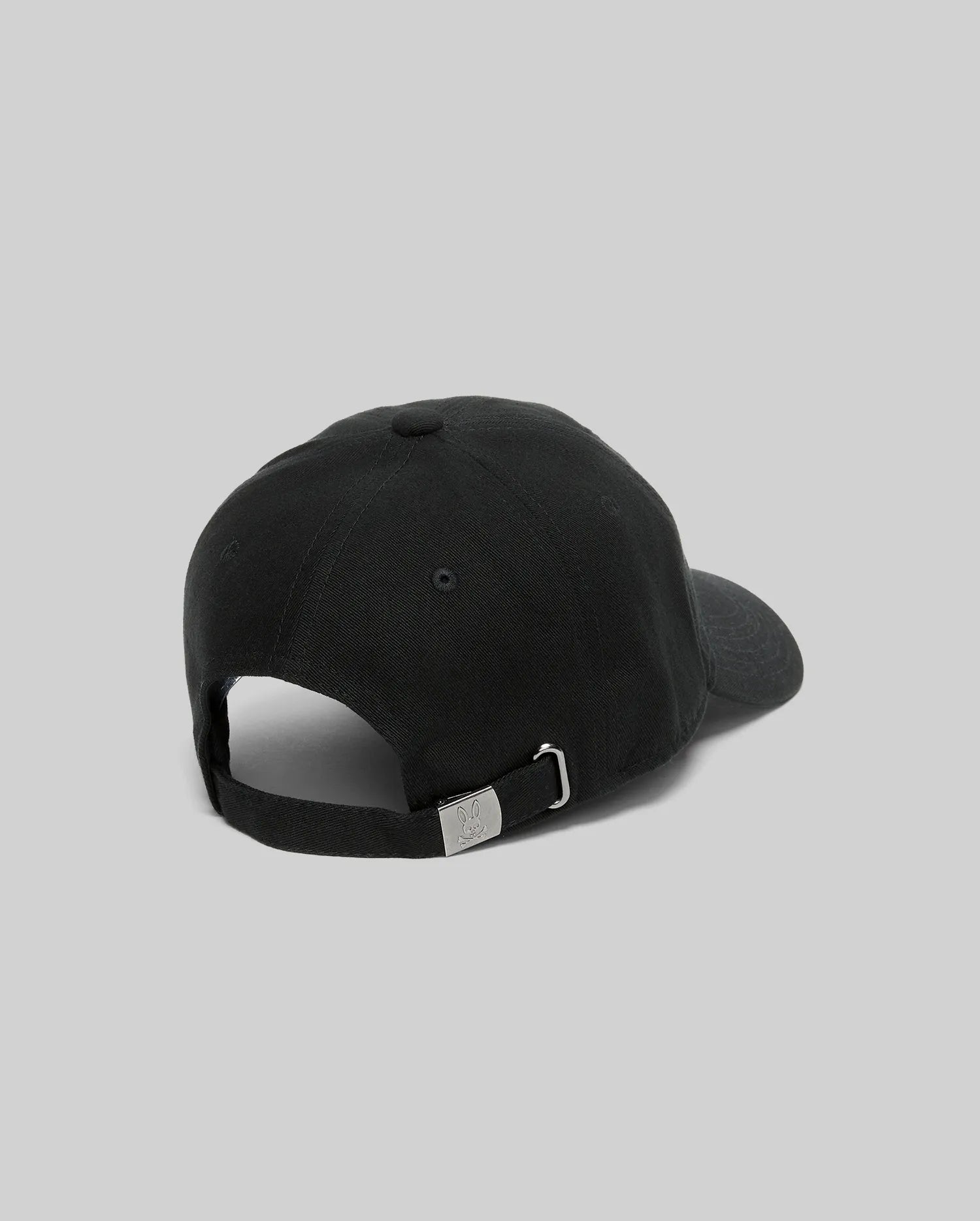 Jimmy Baseball Cap in black cotton twill, featuring a classic fit and an adjustable strap with a silver metal buckle engraved with the iconic Psycho Bunny skull logo at the back.