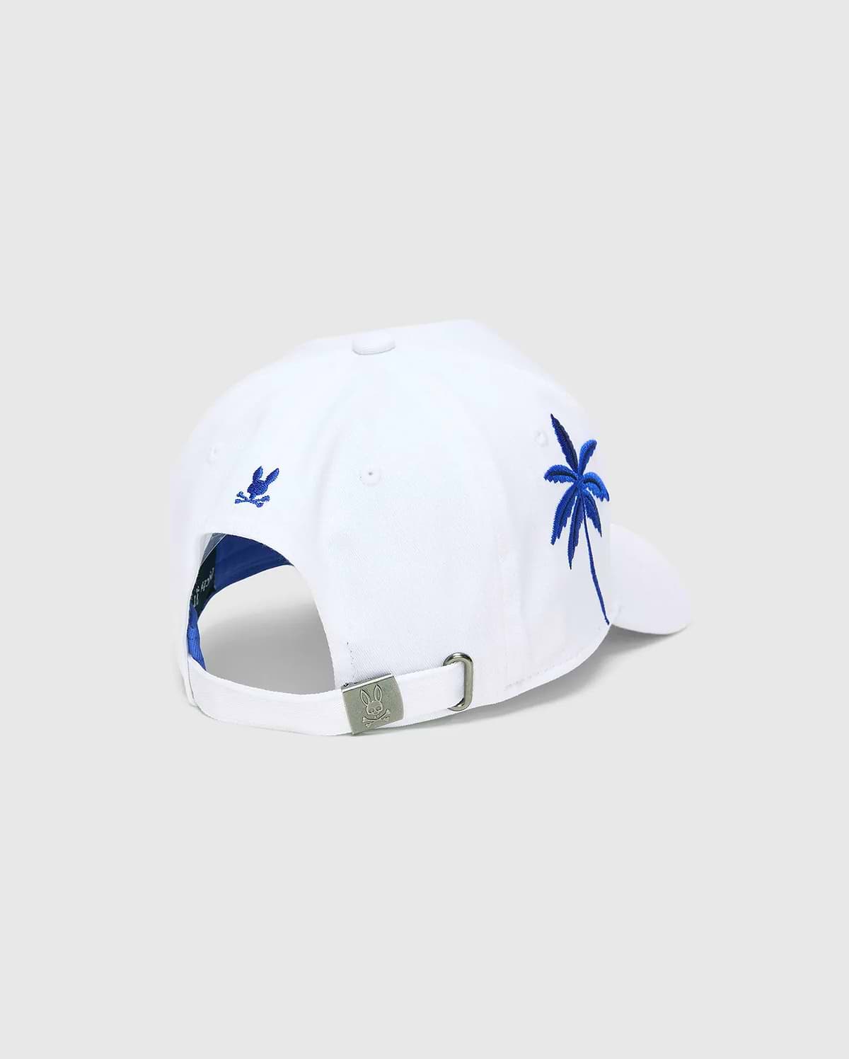 White Mens Brad Trucker Cap with blue interior, featuring a vibrant blue embroidered palm tree on the side, a small blue embroidered Psycho Bunny skull on the back, and a branded metal buckle.