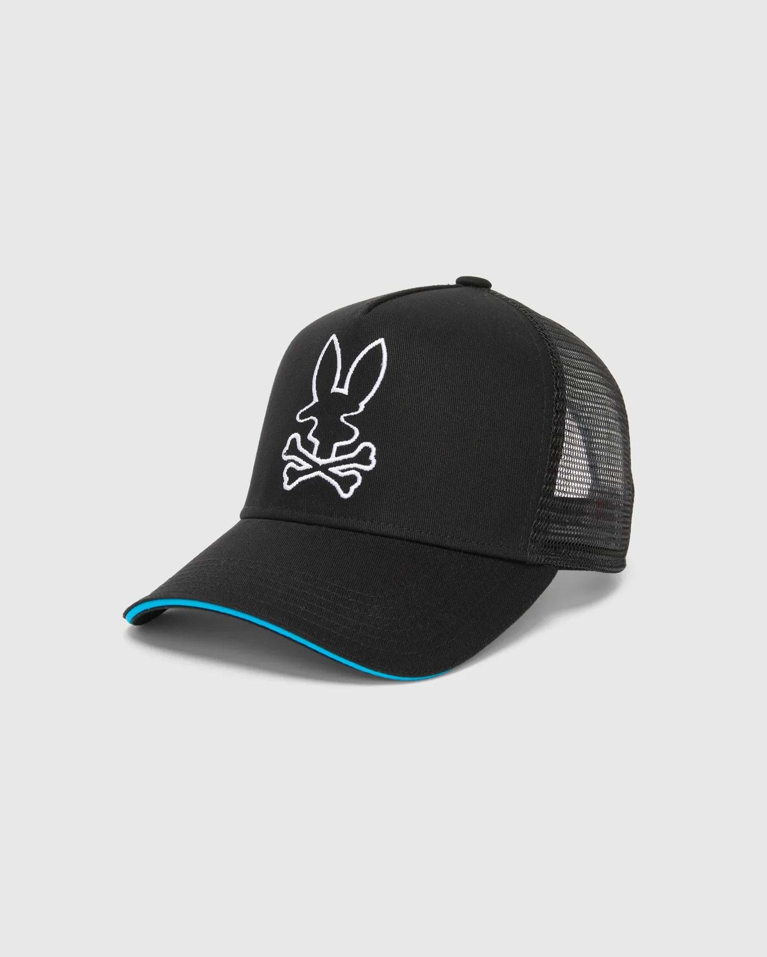 Mens Apollo Trucker Cap in black with a large white embroidered Psycho Bunny skull logo on the front, blue trim on the brim, and breathable mesh back panels.