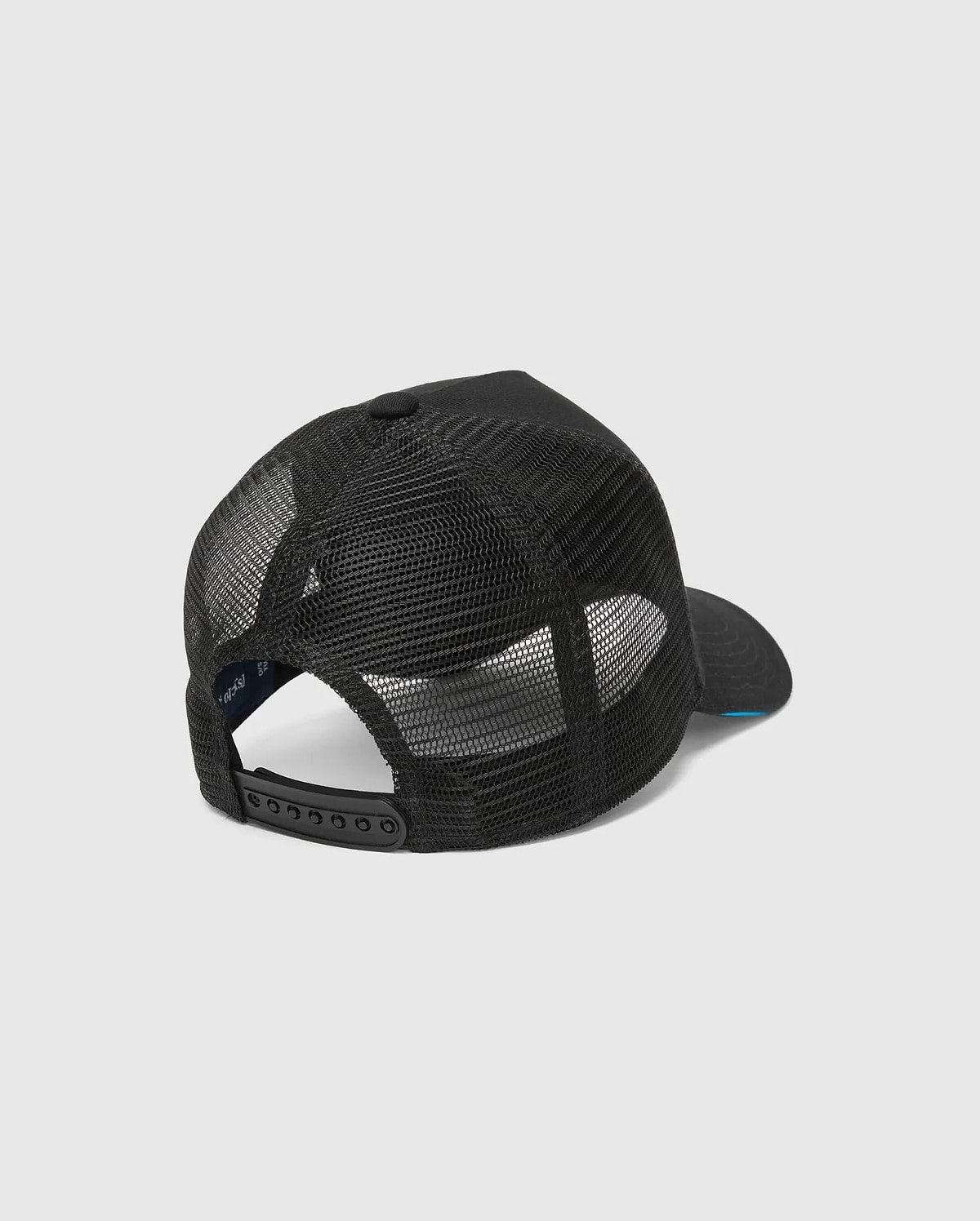 Mens Apollo Trucker Cap in black, featuring breathable mesh back panels, an adjustable snapback closure, and a subtle blue underside brim. Psycho Bunny branding is visible on the inner band.