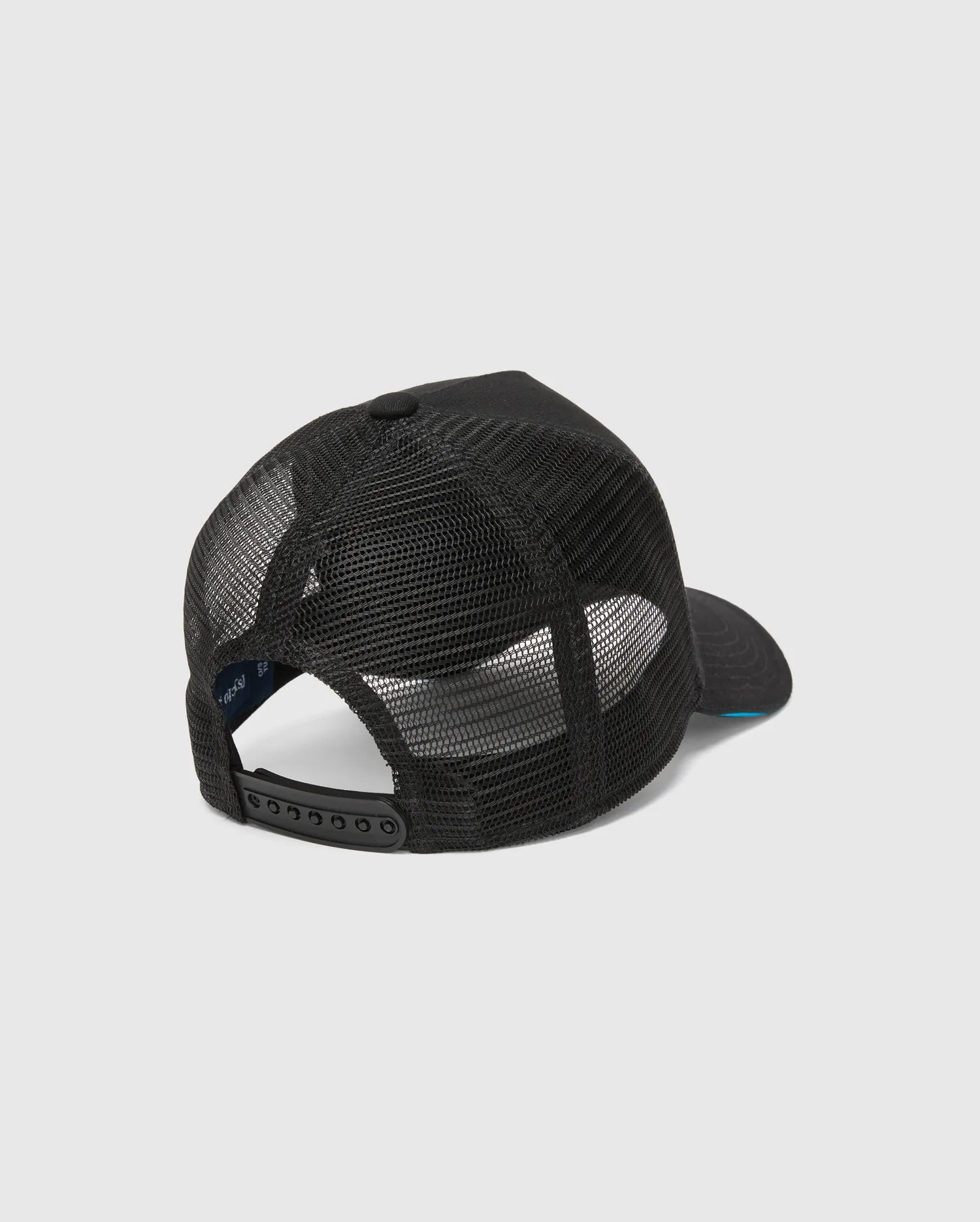 Mens Apollo Trucker Cap in black, featuring breathable mesh back panels, an adjustable snapback closure, and a subtle blue underside brim. Psycho Bunny branding is visible on the inner band.