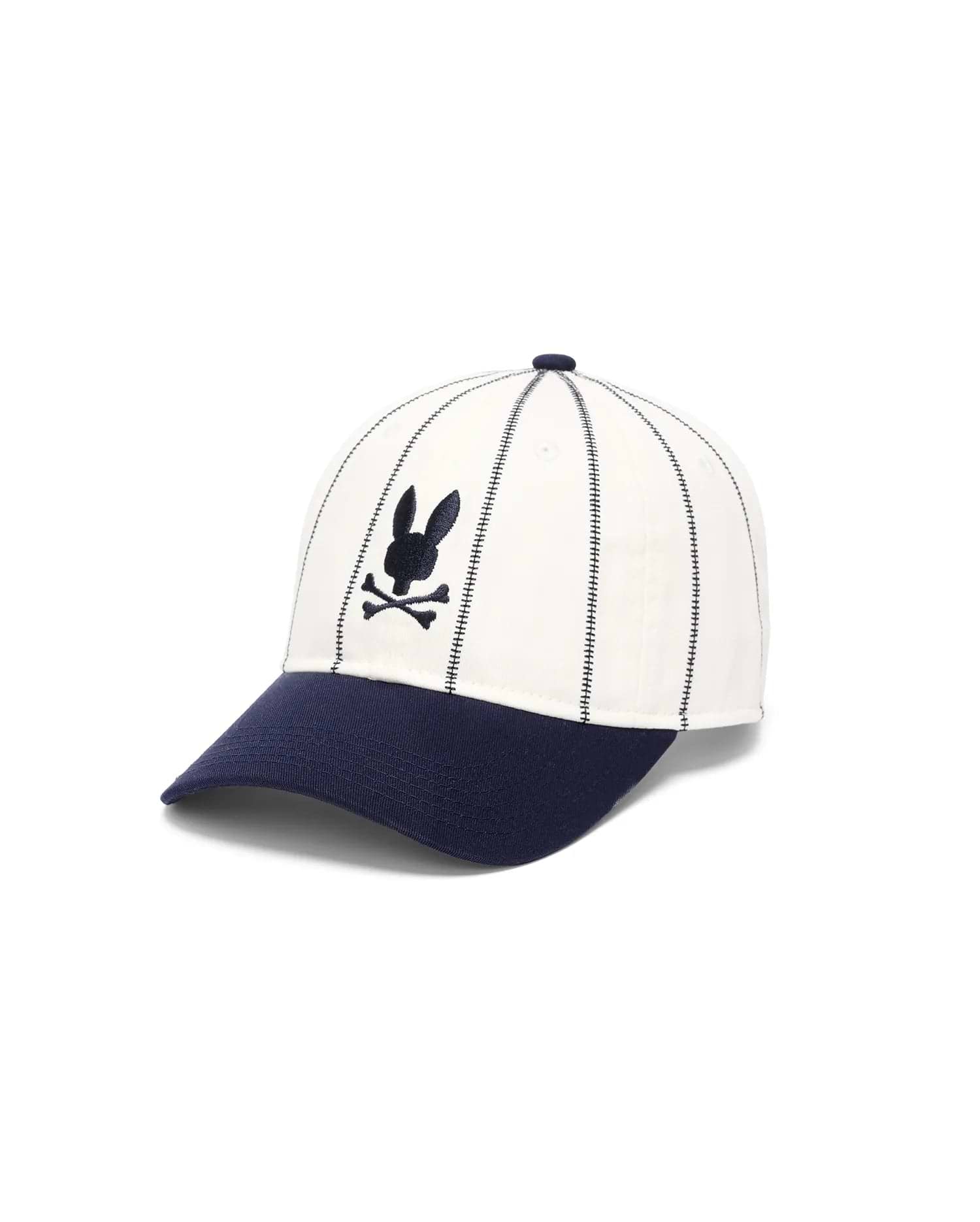 Mens Nathaniel Soft Baseball Cap featuring a cream crown with vertical navy dash stitching, a navy brim, and a front-center embroidered navy Psycho Bunny skull logo.