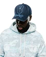 Men's Grover Baseball Cap in dark denim with light blue embroidered Psycho Bunny logo, paired with a relaxed fit french terry hoodie featuring a light blue digital camo print and a small white embroidered Psycho Bunny chest logo. (1)
