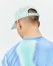 Mens Blaze Sport Cap in mint green with perforated panels and a performance t-shirt featuring a blue and aqua tie-dye gradient, textured mesh fabric, and white Psycho Bunny text on the upper back. (3)