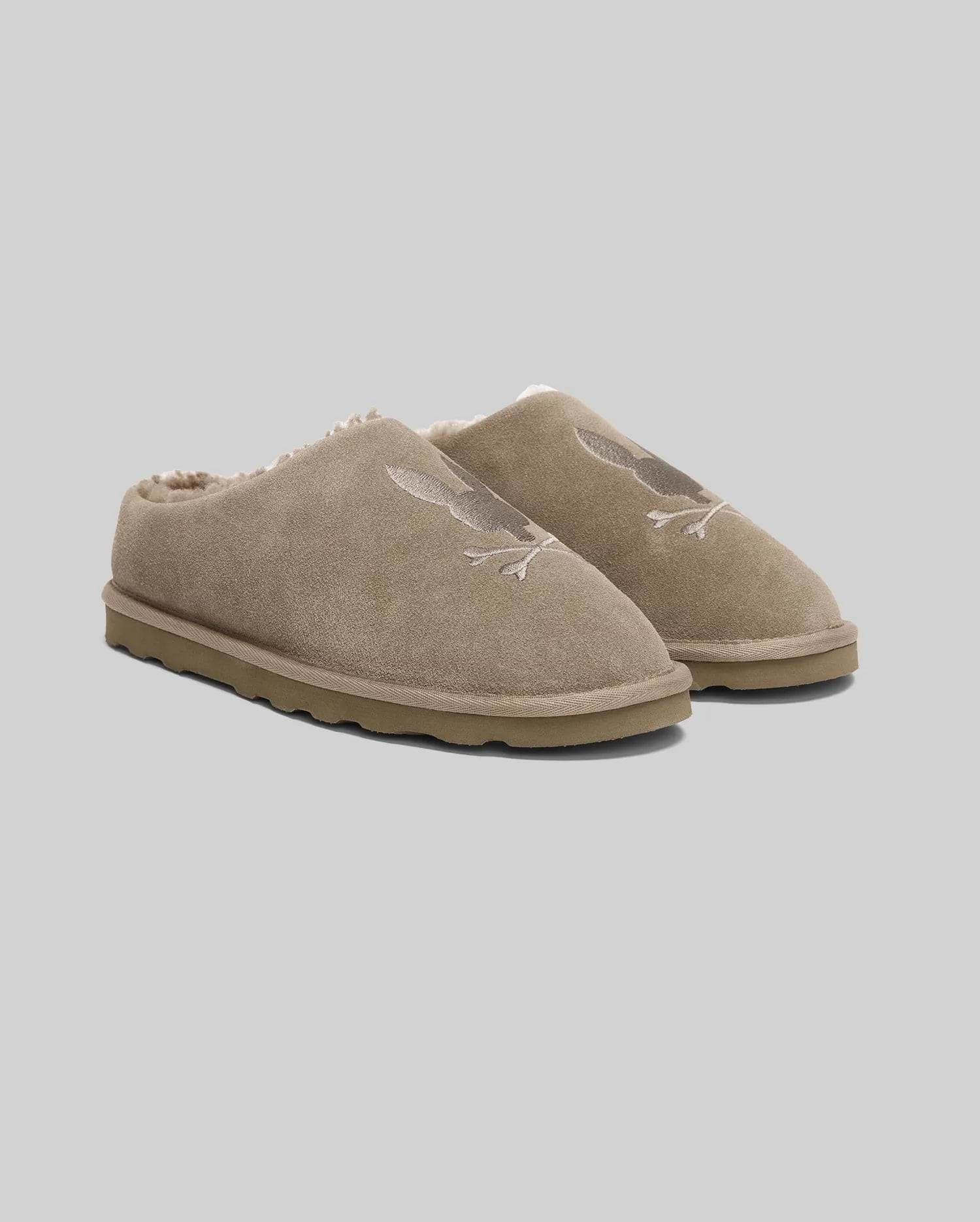 Mens Suede Sherpa Bunny Slipper in tan suede with a tonal embroidered Psycho Bunny skull logo on the vamp and plush cream sherpa lining, featuring a durable sole.