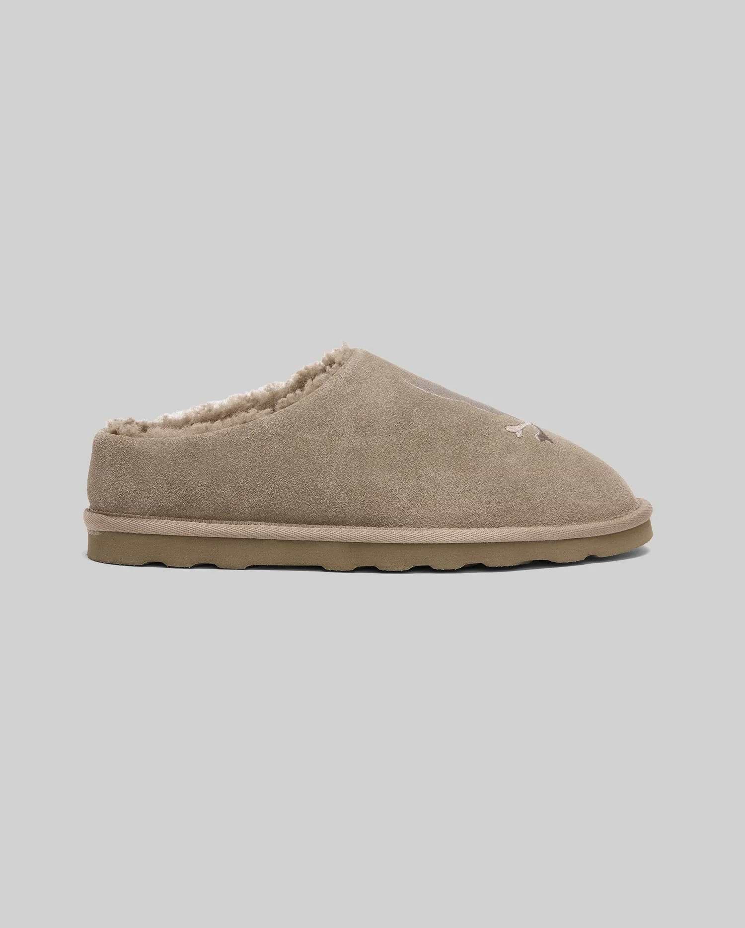 Mens Suede Sherpa Bunny Slipper in tan, featuring a soft suede exterior, plush sherpa lining, and a subtle embroidered Psycho Bunny skull logo on the front.