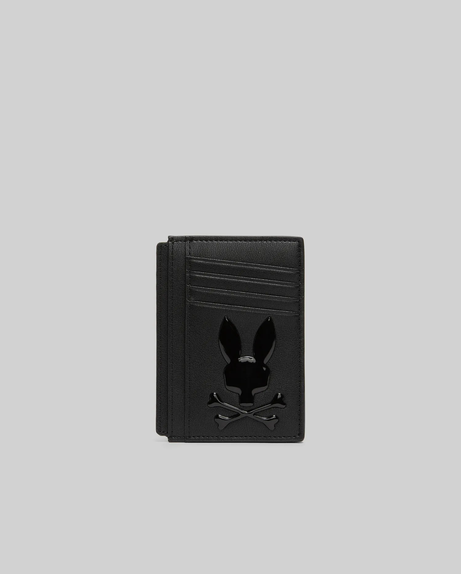 Black textured leather Bunny Card Case featuring multiple card slots and a prominent, glossy black Psycho Bunny skull logo centered on the front.