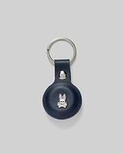 Navy leather Air Tag Holder with a silver keyring and snap closure, featuring a small metallic Psycho Bunny skull logo with pink accents on the front. (1)