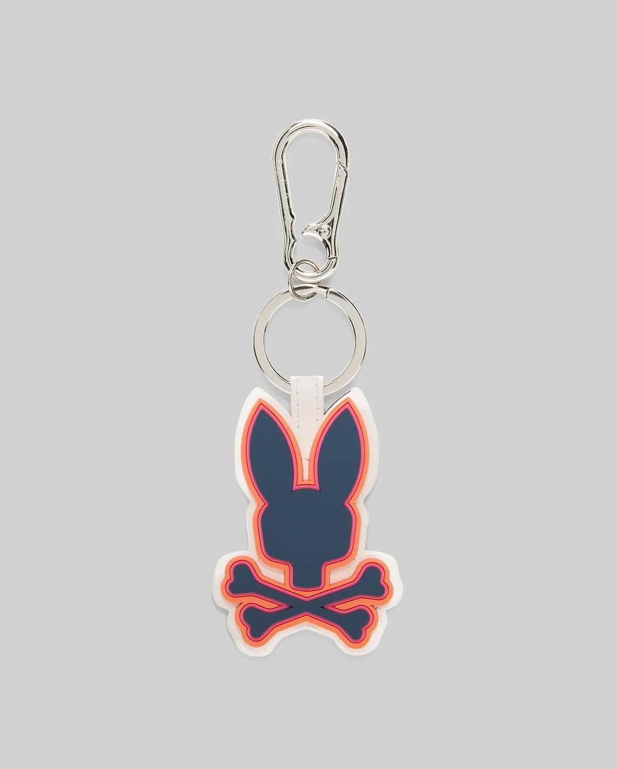 Rubber Bunny Keychain with a prominent navy Psycho Bunny skull and crossbones logo, accented by vibrant orange and pink outlines on a white rubber base, attached to a sleek silver carabiner clip.