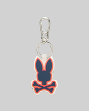 Rubber Bunny Keychain with a prominent navy Psycho Bunny skull and crossbones logo, accented by vibrant orange and pink outlines on a white rubber base, attached to a sleek silver carabiner clip.