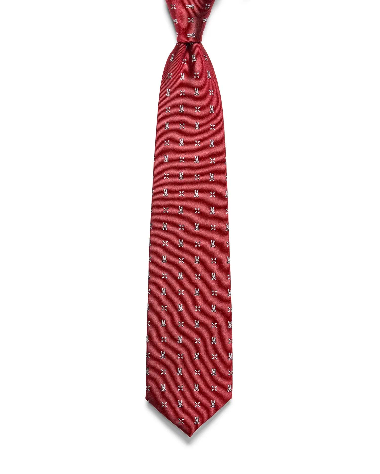 Mens Bunny Neat Woven Tie, a rich red woven tie with a subtle diagonal texture, featuring a repeating pattern of small white Psycho Bunny skull logos and 'X' marks.