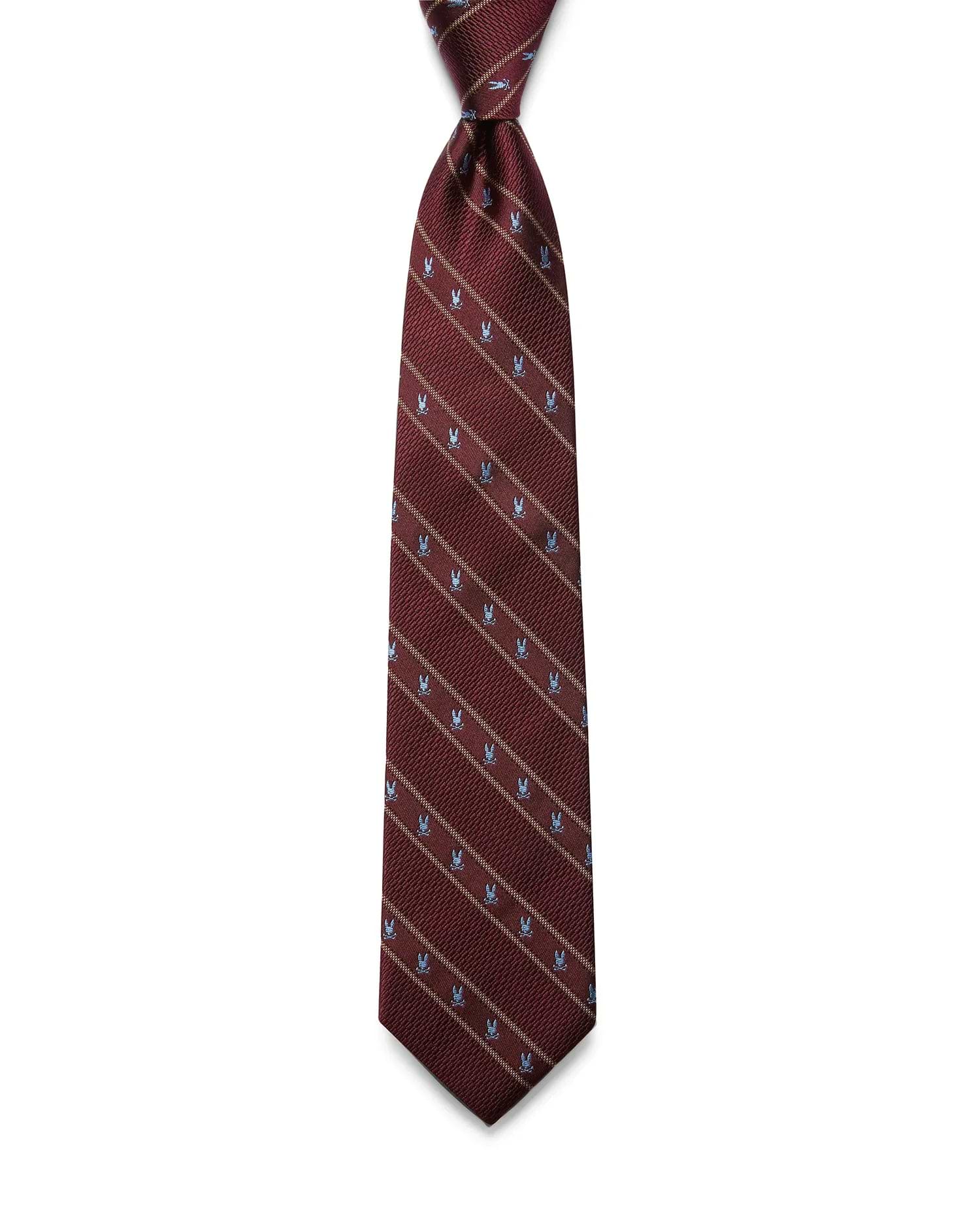 Mens Bunny Stripe Woven Tie in rich burgundy, featuring diagonal tan stripes and an all-over pattern of small, light blue Psycho Bunny skull logos with a refined woven texture.
