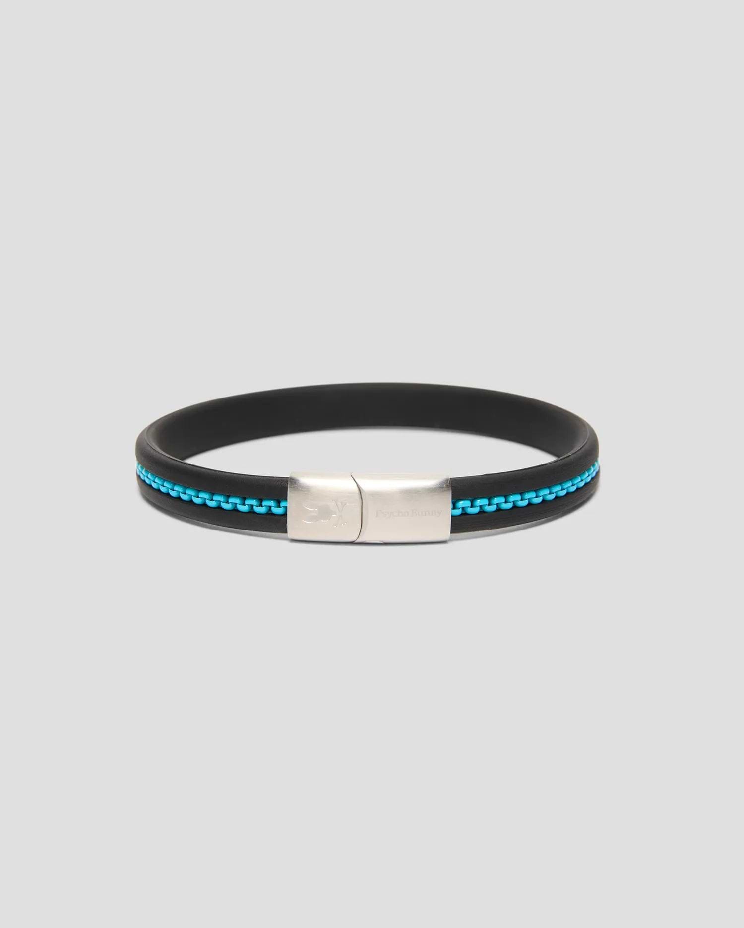 Mens Link Rubber Bracelet, a sleek black rubber band with a vibrant turquoise chain-link inlay and a polished silver clasp featuring engraved Psycho Bunny branding and skull logo.