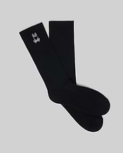 Mens New Classic Sport Sock, premium black ribbed knit crew socks featuring a small, crisp white embroidered Psycho Bunny skull logo prominently on the outer ankle cuff. (1)