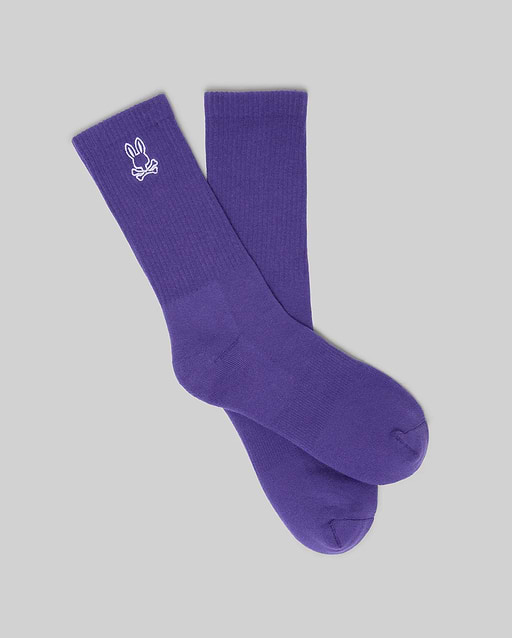 MENS NEW CLASSIC SPORT SOCK, a vibrant purple crew sock featuring a prominent white embroidered Psycho Bunny skull logo on the ribbed cuff, embodying refined streetwear style.