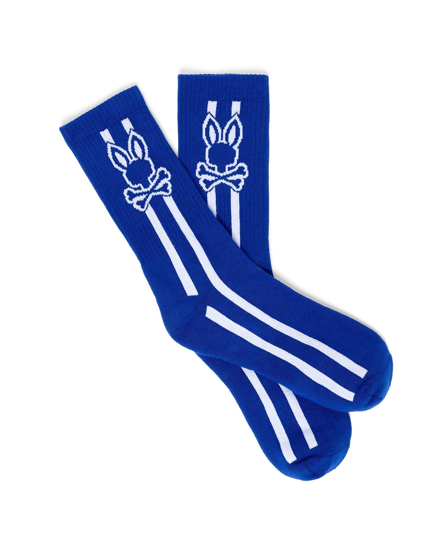 Mens Ty Sport Sock in vibrant royal blue knit, featuring a prominent white Psycho Bunny skull logo graphic on the calf, flanked by two vertical white stripes and two horizontal white stripes below.
