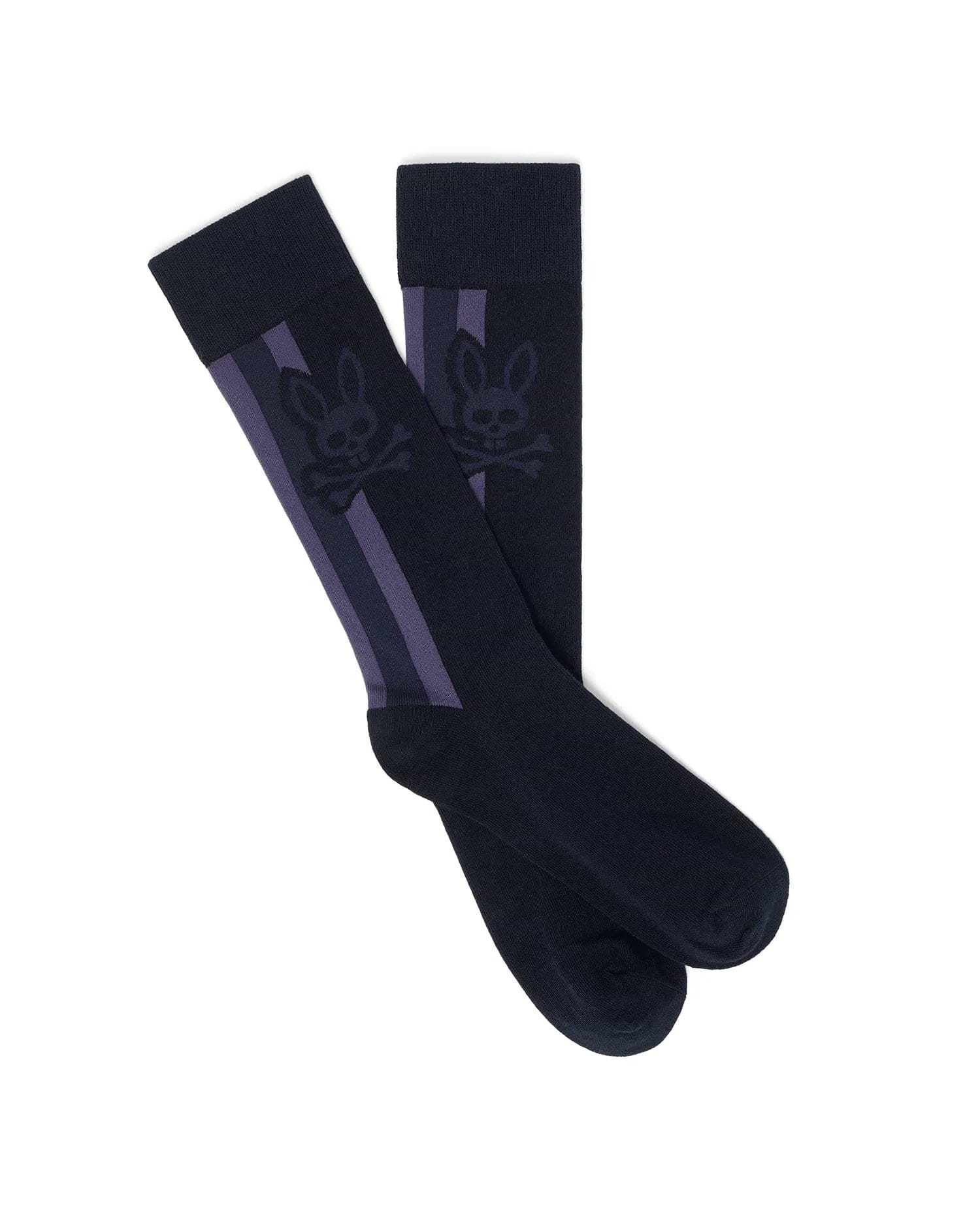 Mens Ty Dress Sock in deep navy fine knit, featuring prominent vertical purple stripes and a large, repeated tonal Psycho Bunny skull logo woven into the calf.